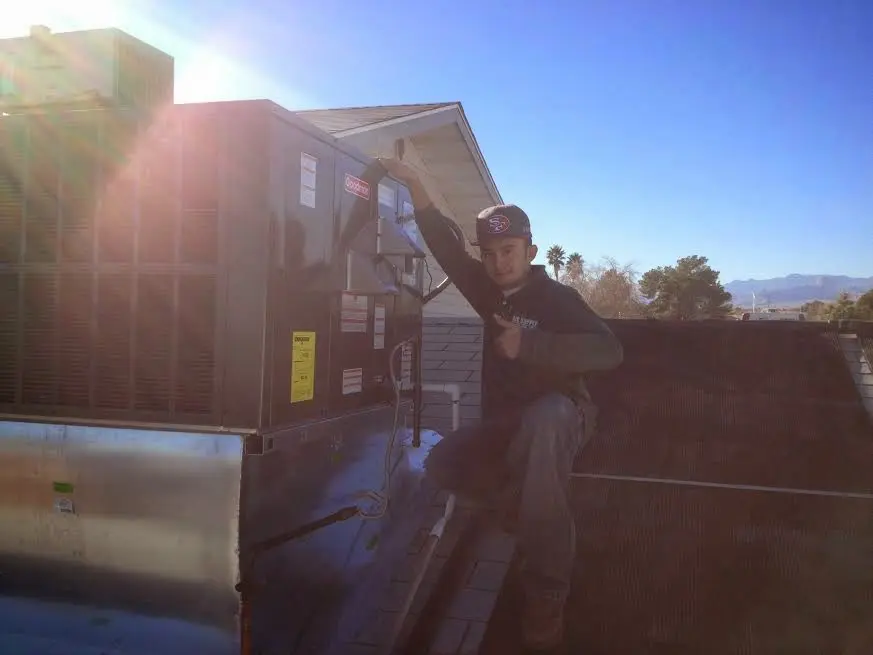 HVAC technician performing Boiler Repair on a rooftop unit in Hollins